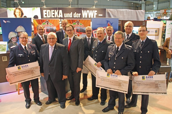 Den Löwenanteil in Höhe von 34.710 Euro nahm der schleswig-holsteinische Landes-Jugendfeuerwehrwart Dirk Tschechne von Carsten Koch (lks., Geschäftsführer EDEKA Nord) entgegen. Landtagspräsident Klaus Schlie und Neumünsters Oberbürgermeister Dr. Olaf Tauras assistieren. Foto: Bauer/Feuerwehr