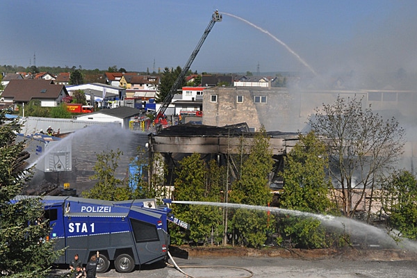 Drehleiter und Wasserwerfer der Polizei bei Löscharbeiten während eines Großbrandes. Foto: Andreas Rosar Fotoagentur-Stuttgart