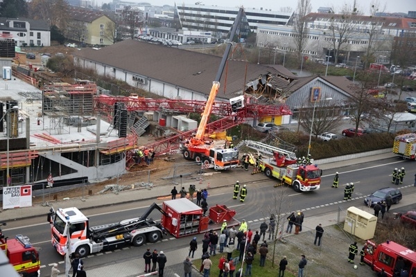 Ein Kran ist in Bad Homburg auf einen Aldi-Markt gestürzt. Im ersten Angriff sind eine Drehleieter und der Feuerwehr-Kran der Berufsfeuerwehr Frankfurt am Main im Einsatz. Foto: Storch