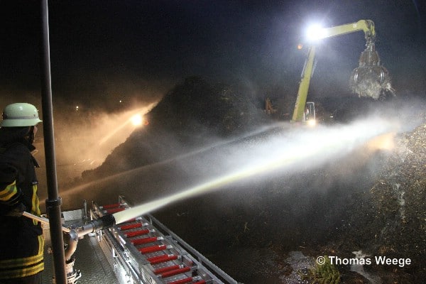 Viel hilft viel. Der brennende Haufen mit einem Volumen von über 2.000 Kubikmetern wurde hauptsächlich mit Wasserwerfern gelöscht. Bagger schichten schichten den Haufen für die Löscharbeiten um.