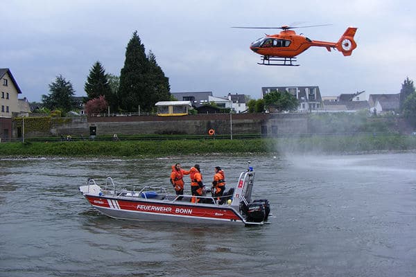 Rettungshubschrauber "Christoph 3" und ein Mehrzweckboot der Feuerwehr Bonn eilen einem Mann im Rhein zur Hilfe. Foto: Feuerwehr Bonn