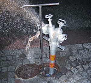 Trinkwasserschutz bei Feuerwehreinsatz: Am Standrohr beginnen die ersten Fehler im Trinkwasserschutz. Beim Öffnen des Hydranten sollte zumindes eines der Standrohrventile bereits geöffnet sein, um zu spülen. Ansonsten schießt der erste Druckstoß verdrecktes Hydranten- und Rohrleitungswasser ins Trinkwasser. Foto: Patzelt