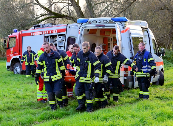 Weil der Rettungswagen festgefahren ist, retten Einsatzkräfte eine verunfallte Frau mit Hilfe einer Schleifkorbtrage. Foto: Mücke