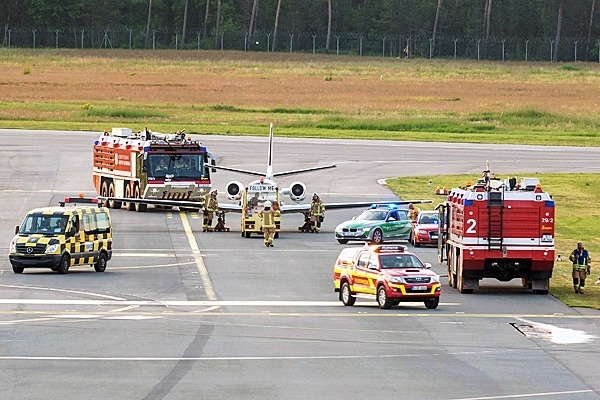 Kräfte der Feuerwehr sichern die Maschine während sie vom Rollfeld gezogen wird. Foto: News5 / Linschmann
