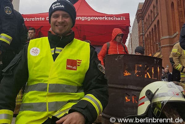 Der Verdi Betriebsgruppensprecher Stefan Ehricht neben der #BerlinBrennt Tonne