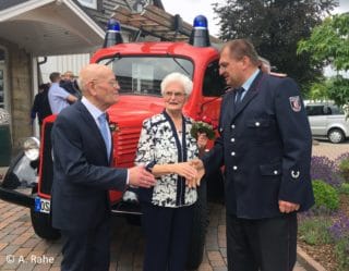 Eheleute vor Feuerwehrfahrzeug