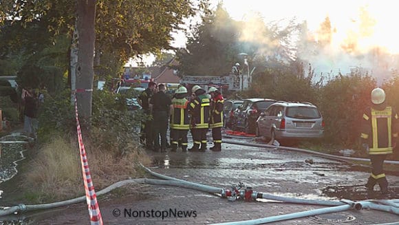 Feuerwehr auf Straße vor zerstörtem Haus