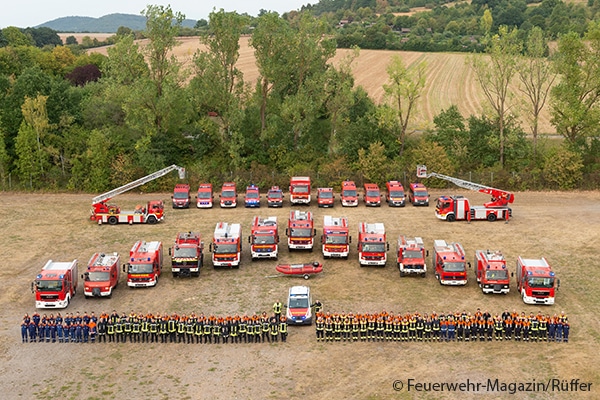 Die Feuerwehren von Bad Kissingen mit Feuerwehrfahrzeugen auf einer grünen Wiese