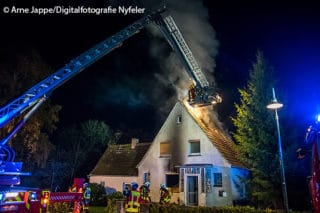 Von einem einem Teleskopmast aus löscht die FF Scharbeutz Glutnester im Dachstuhl eines Einfamilienhauses.