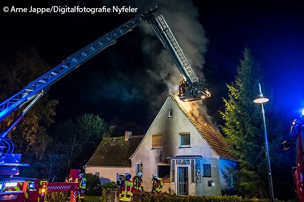 Von einem einem Teleskopmast aus löscht die FF Scharbeutz Glutnester im Dachstuhl eines Einfamilienhauses. 