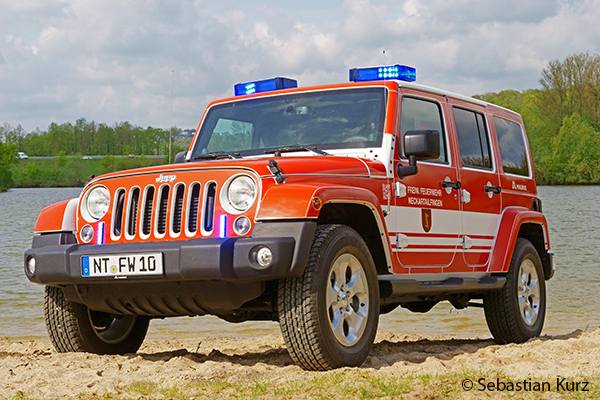 Ein Jeep der Feuerwehr Neckartailfingen steht am Strand eines Badeseesteht 