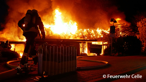 Bei Eintreffen der Feuerwehr Celle an einem Gartencenter steht das Gebäude in Vollbrand. Einsatzkräfte bereiten die Brandbekämpfung vor.