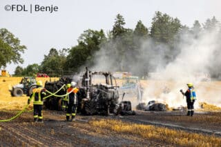 Ein Traktor mit Quaderballenpresse brennt auf einem Feld komplett aus. Es entsteht hoher Sachschaden.