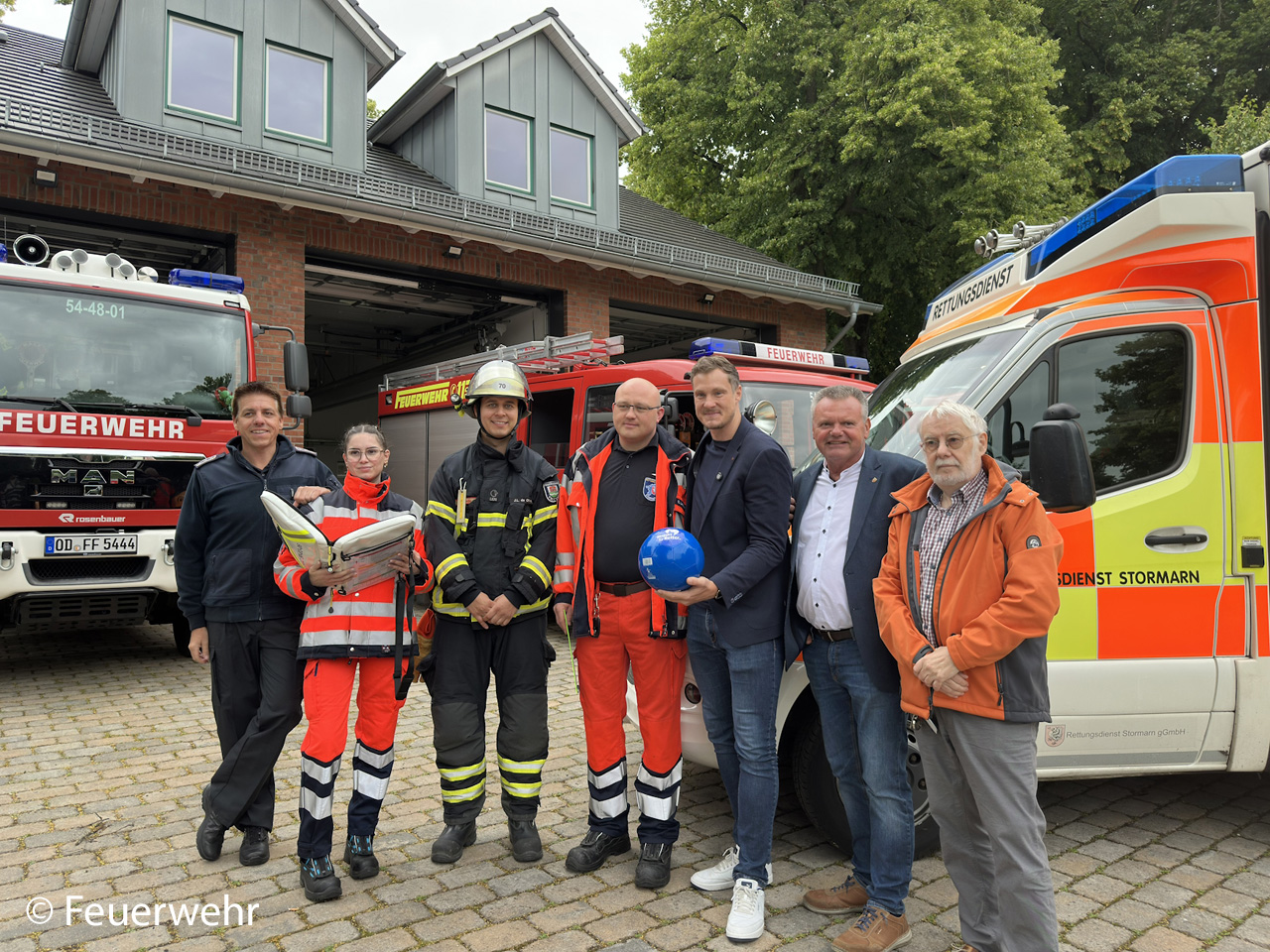 Marcell Jansen mit Einsatzfahrzeugen und Rettungskräften bei einer Foto- und Video-Aktion vor der Feuerwache. Foto: Feuerwehr