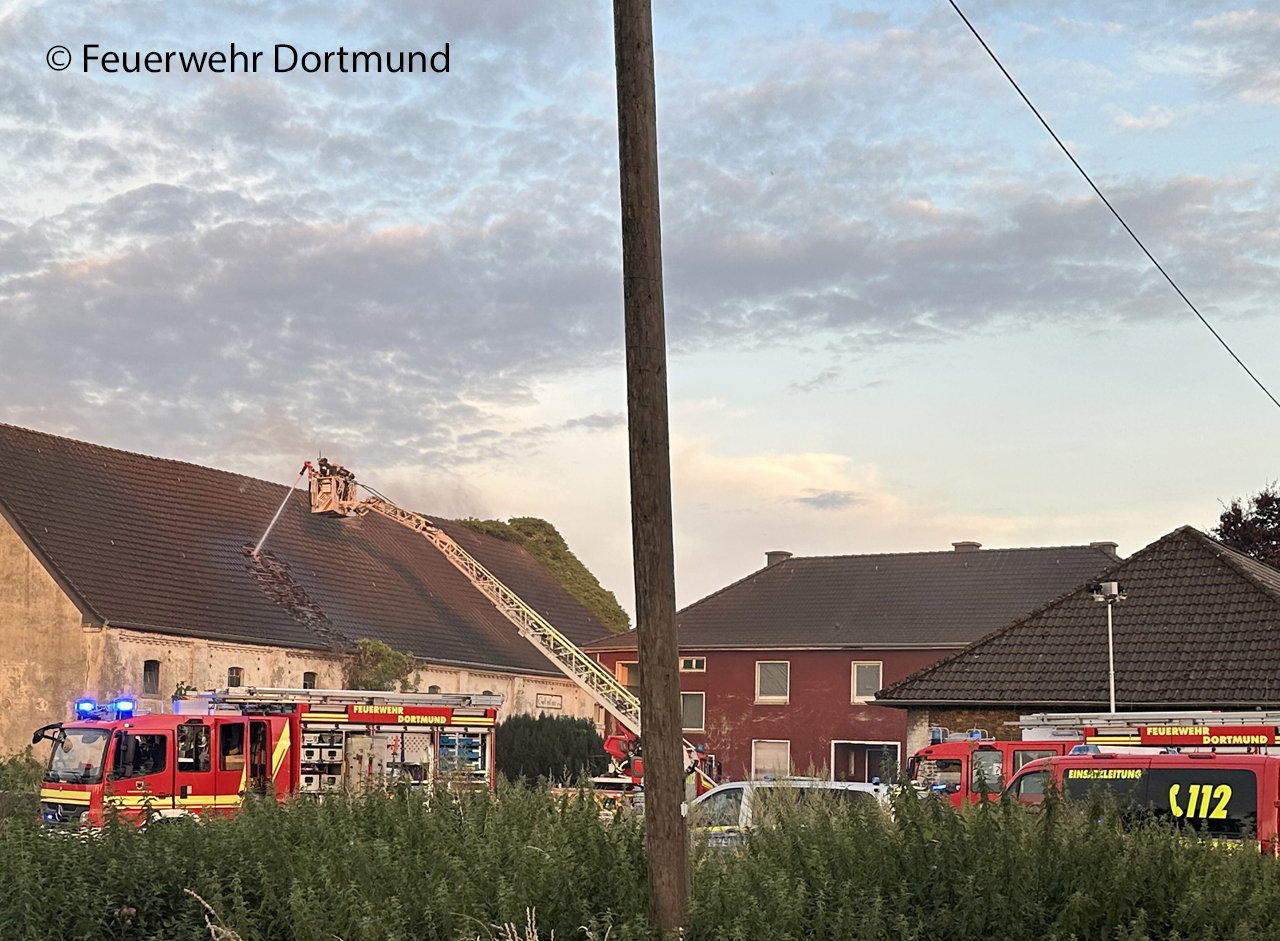 Bei dem Scheunenbrand in Dortmund-Scharnhorst zieht heißer Brandrauch bis unters Dach. Ein Trupp kontrolliert unter Atemschutz von einer Drehleiter aus das Gebäude und entfernt die Dachpfannen. Foto: Feuerwehr Dortmund