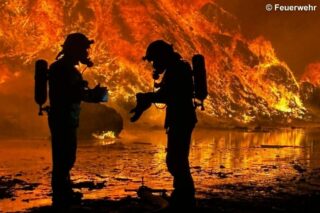 Feuerwehr-Silhouetten vor Flammen