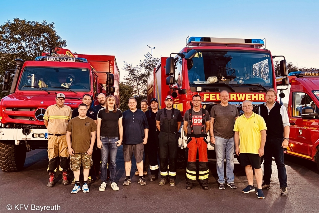 Gruppenfoto vor zwei Fahrzeugen