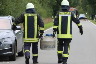Einsatzkräfte tragen zu zweit Behälter