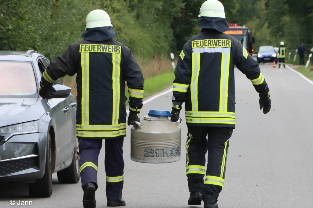 Einsatzkräfte tragen zu zweit Behälter