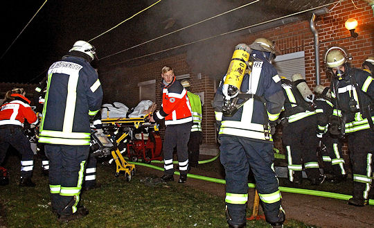 Brand in Nordhorn: Rettungsdienstkräfte transportieren einen schwer verletzten Mann ab. Foto: Stephan Konjer