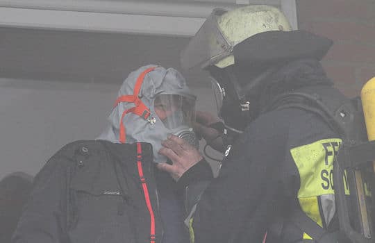 Feuer in Tiefgarage in Schwarzenbek: Ein Anwohner wird mit einer Fluchthaube von der Feuerwehr gerettet. Foto: Timo Jann