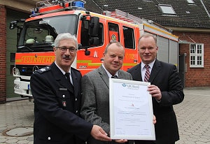 Hamburgs Feuerwehrchef Klaus Maurer (links) und Michael Neumann, der Innensenator der Hansestadt (rechts) nahmen von Hans-Jürgen Müller von der Unfallkasse Nord das Gütesiegel für das qualifizierte Arbeitsschutz-Managementsystem entgegen. Foto: Timo Jann