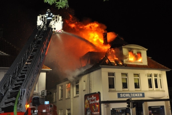 Ein Wohn- und Geschäftshaus steht in Oldenburg in Flammen. Die Feuerwehr löscht von einer Drehleiter aus die Flammen. (Foto: Polizei)