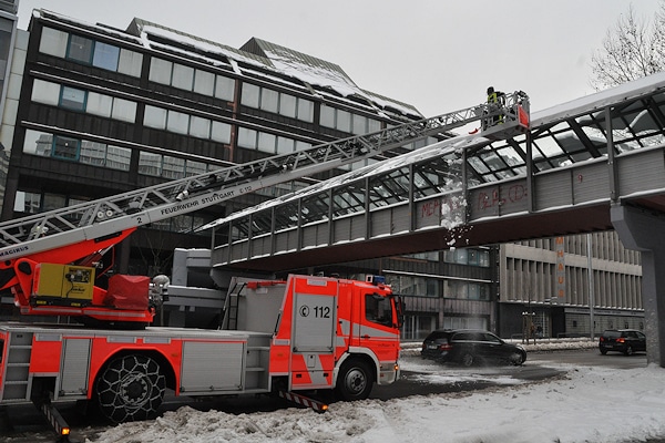 Drehleiter im Wintereinsatz: Die Feuerwehr Stuttgart entfernt Schnee vom Glasdach einer Fußgängerbrücke. Archivfoto: Andreas Rosar