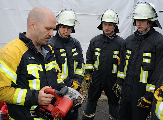 Feuerwehr-Ausbildung: Ausbilder Thorsten Weber erklärt den Neulingen Timo Lahr, Frank Höhne und Ralf Trump (v.l.n.r.) Technik und Funktion der elektrischen Akku-Kreissäge. Foto: Scheer