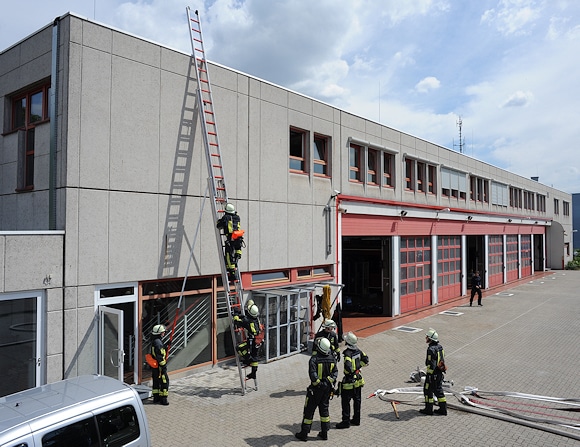 Einsatz der dreiteiligen Schiebleiter vom Hof der Feuerwache Nord auf die Dachfläche. Beim ersten Versuch am Vormittag durch eines der Fenster im Obergeschoss hat es zwei Paneele der Deckenverkleidung erwischt. Wo gehobelt wird… Foto: Scheer