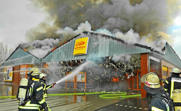 Einsatzkräfte während der Löscharbeiten bei einem Supermarktbrand in Nordhorn. Foto: Konjer