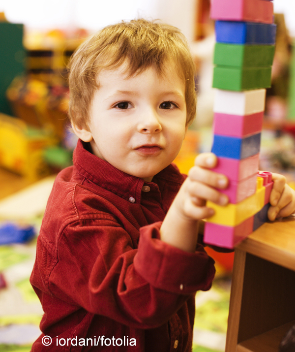portrait of little cute boy making towel with lego close up