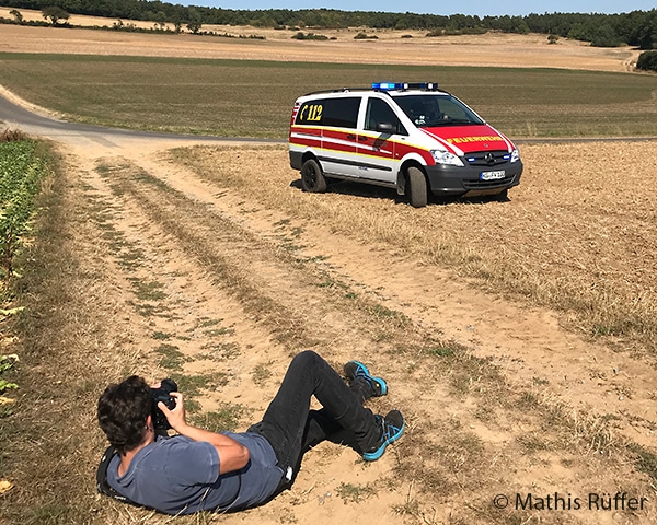 Ein Feuerwehr-Magazin-Redakteur fotografiert ein Einsatzfahrzeug für eine Reportage.